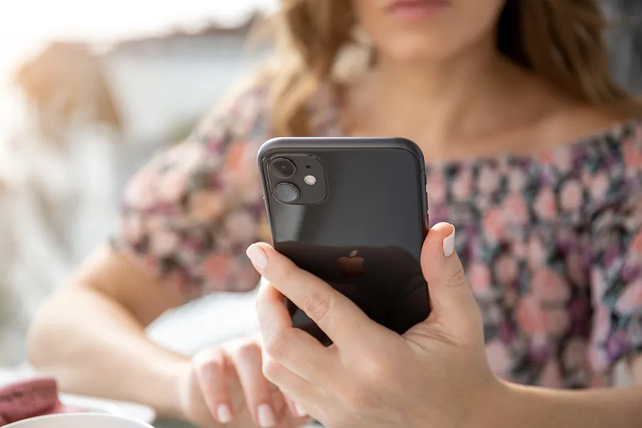 一位手持iPhone 11的女性
