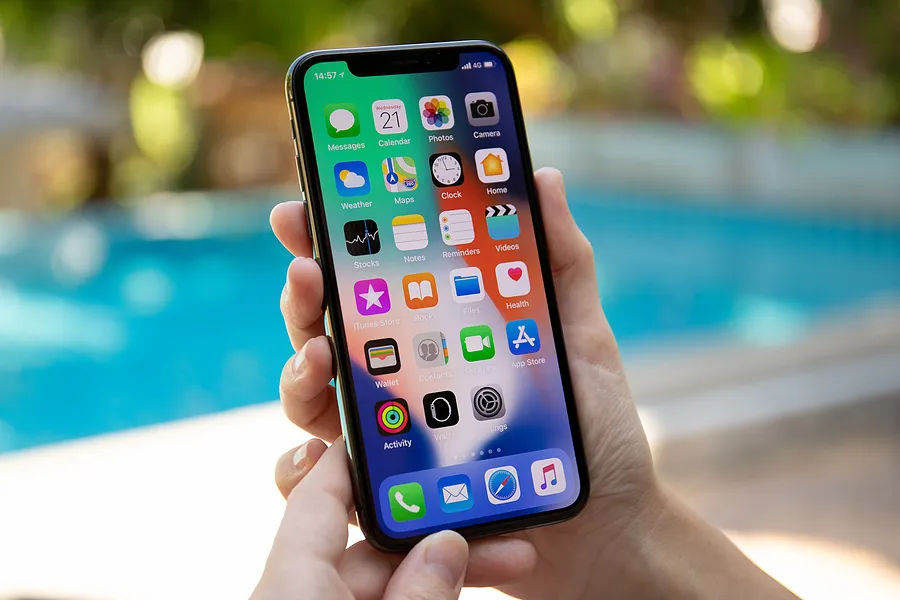 手持iPhone在户外展示iPhone的“原彩显示”功能。